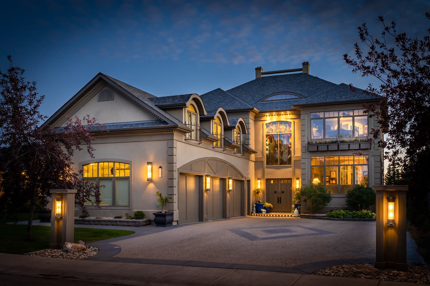 Luxury estate exterior at dusk with pillar lighting