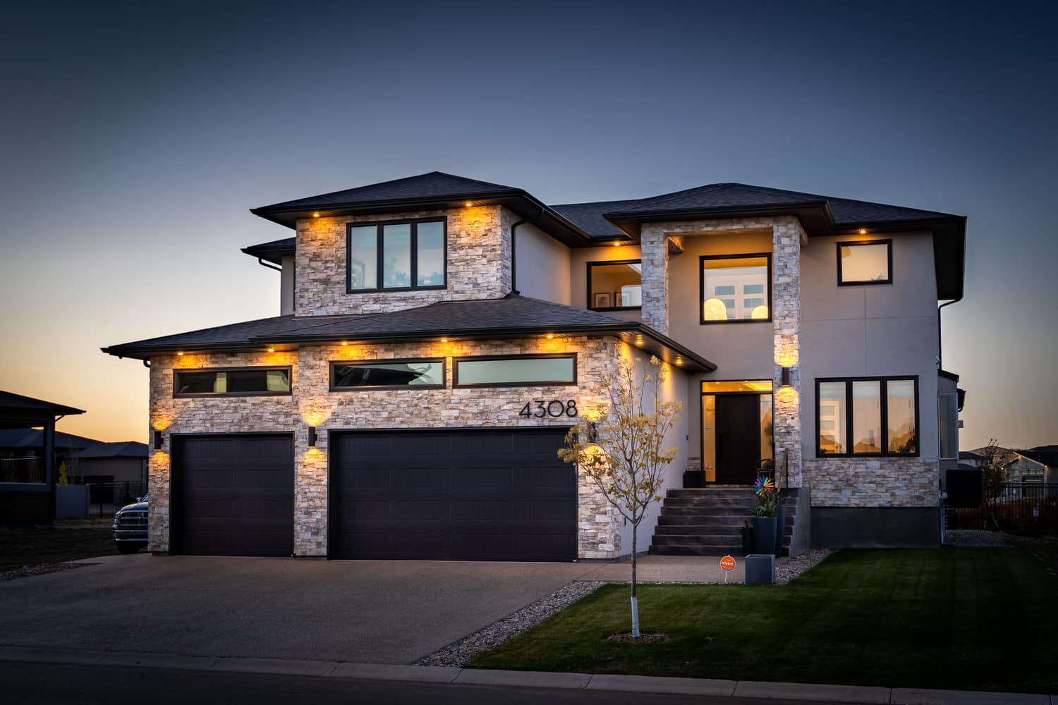 Twilight exterior of stone-front two-storey home