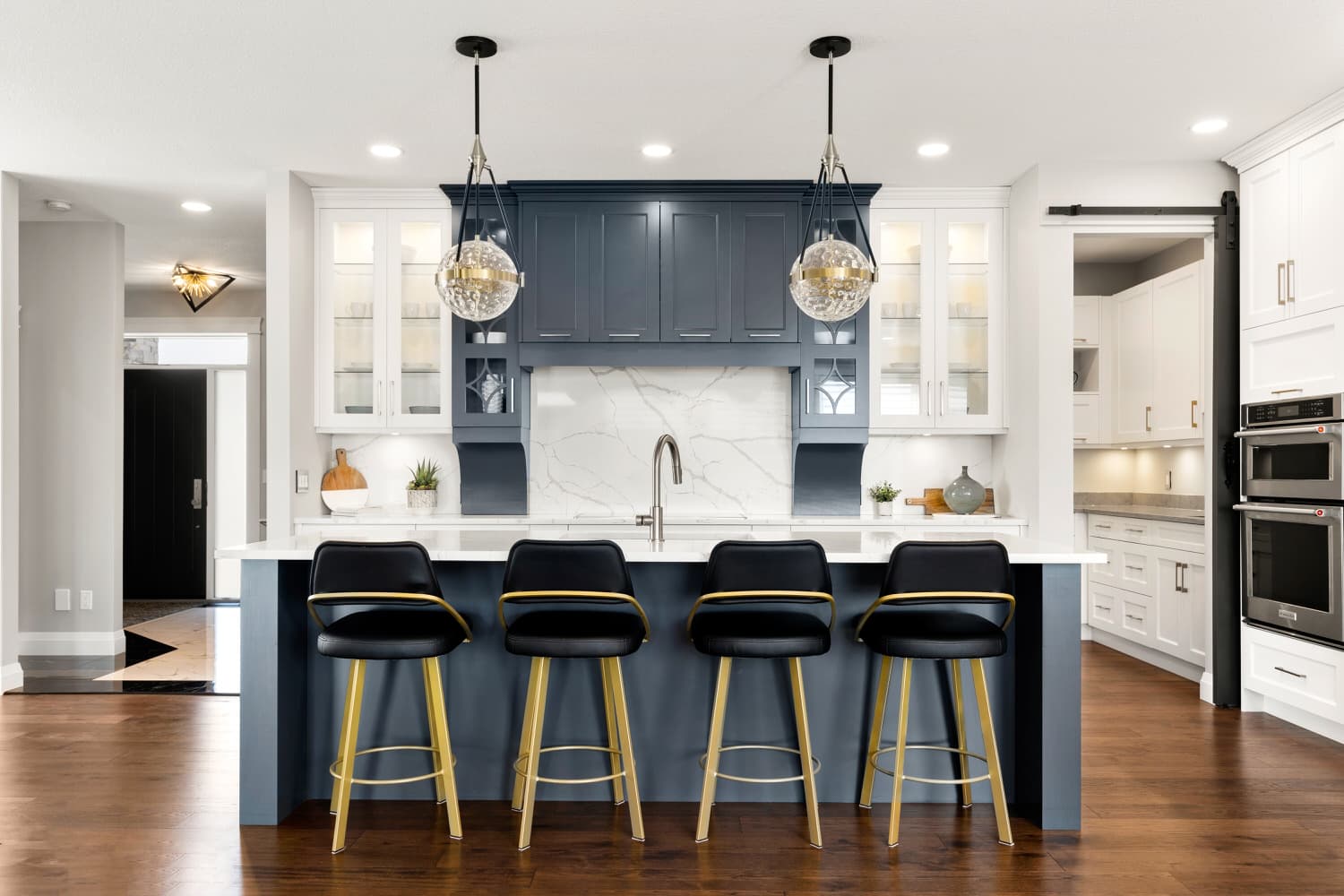 Navy and white kitchen island with marble backsplash