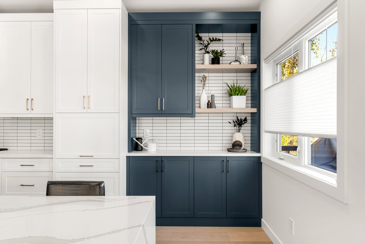Kitchen butler pantry with navy cabinetry and tile backsplash