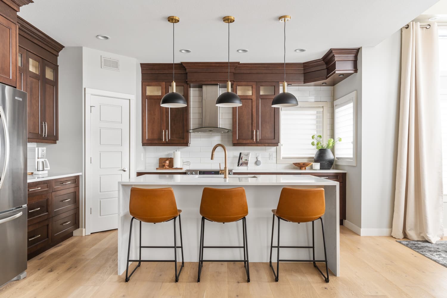 Kitchen with dark wood cabinetry and leather counter stools